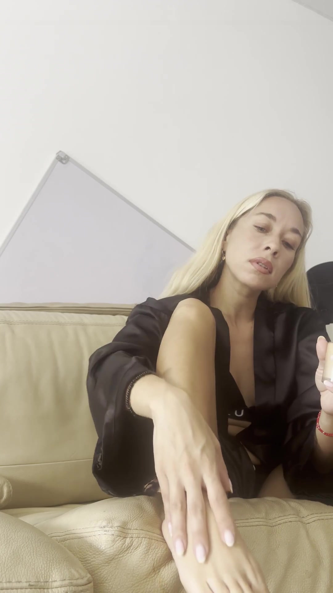 Beautiful blonde applies cream to her feet